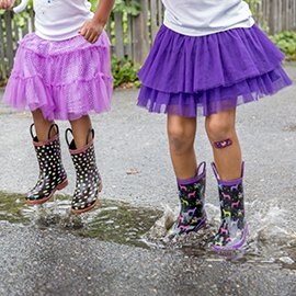 Deux petites filles avec des pansements Nexcare™ jouant dans une flaque